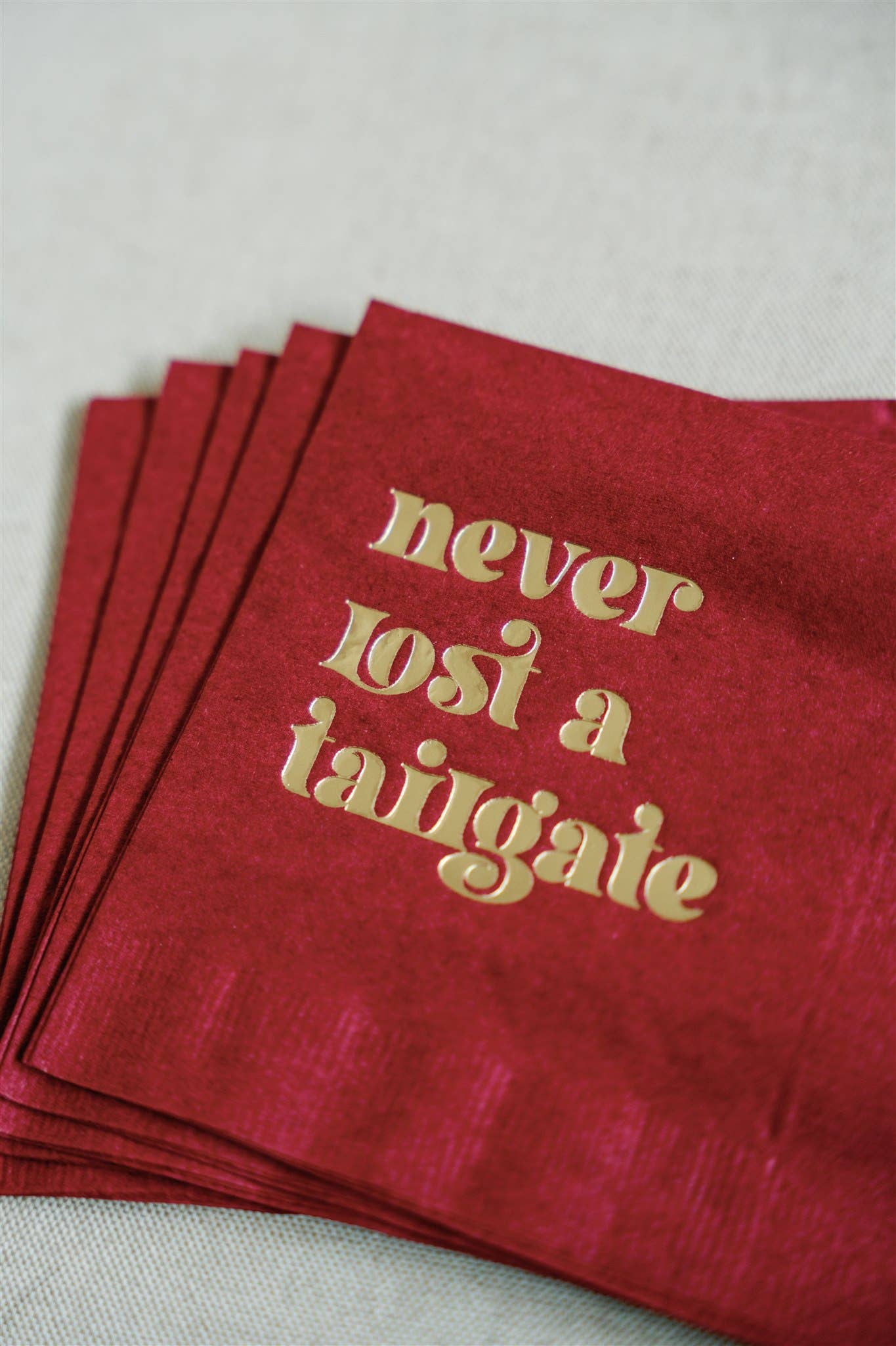 "Never Lost a Tailgate" gold foil + red napkin pack