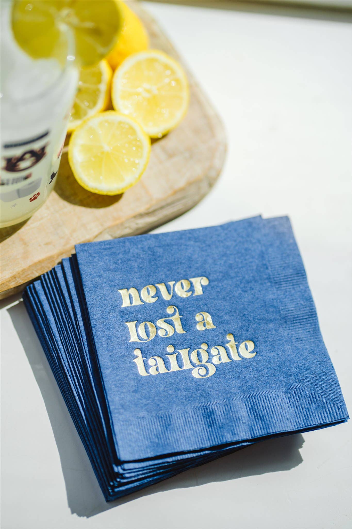 "Never Lost a Tailgate" gold foil + navy napkin pack